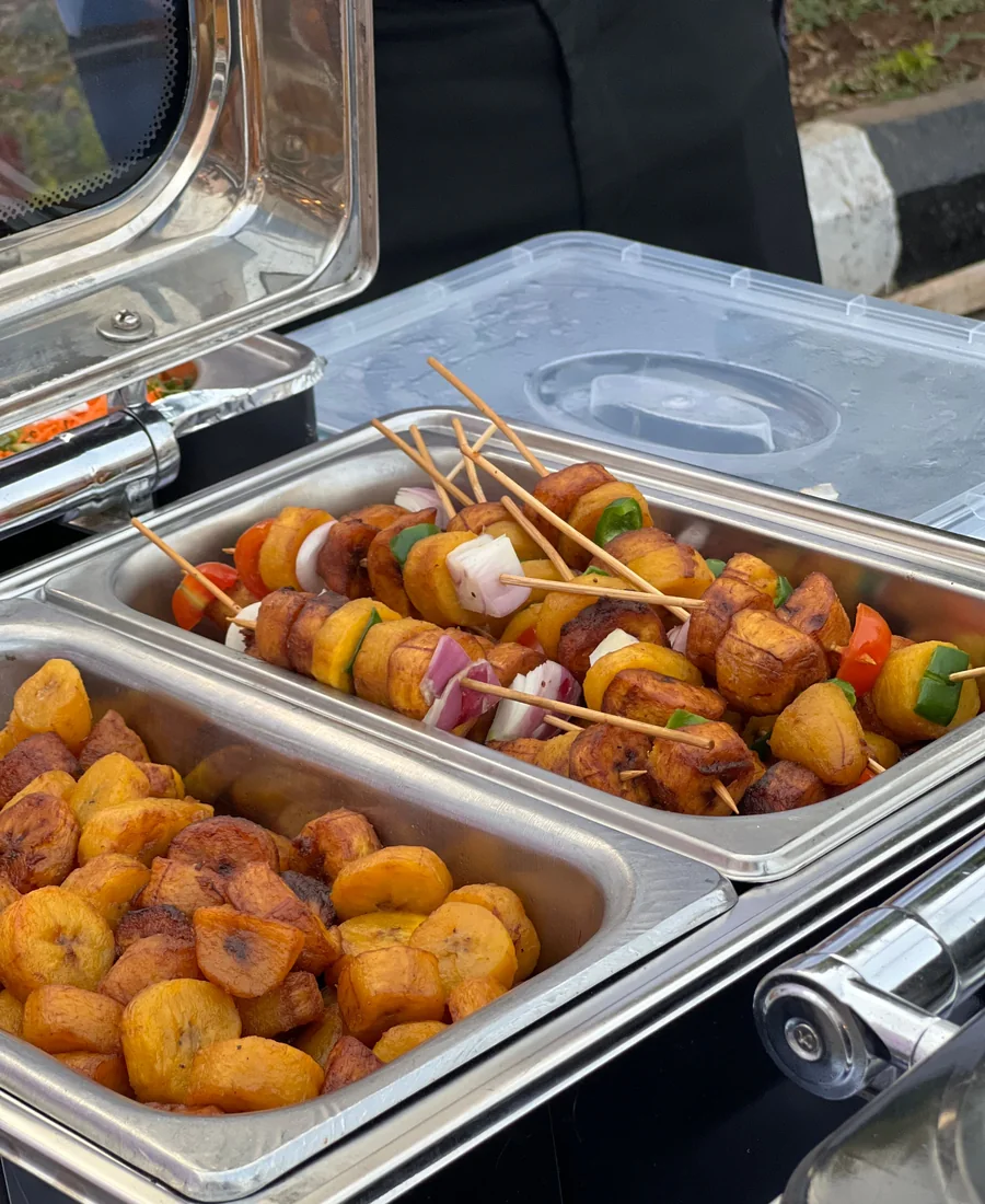 Skewered vegetables and fried plantain laid out in buffet serving trays (representative photograph of a buffet spread, not the Ranch's own table)