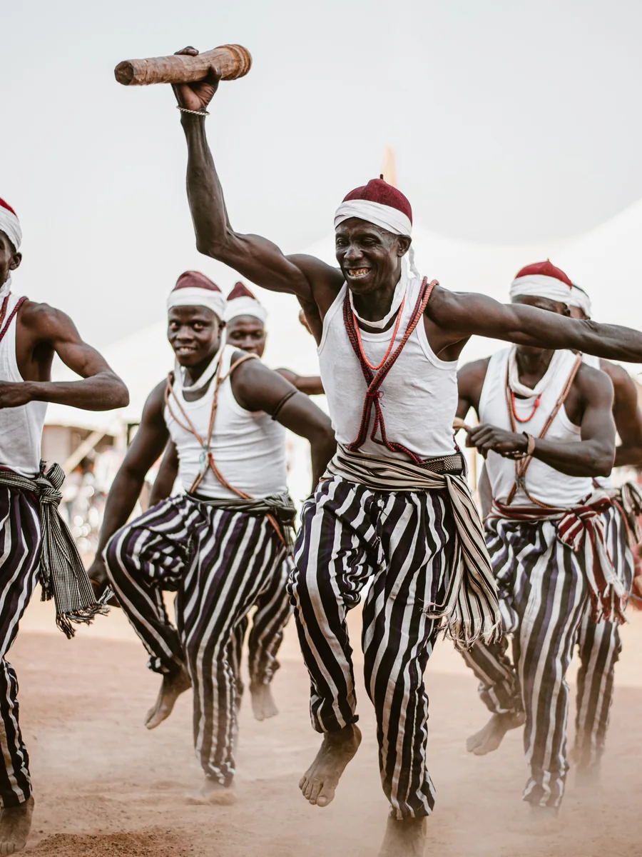 Traditional dancers in striped costume mid-jump during a cultural performance in Ilorin, Nigeria (representative photograph of African dance, not the Safari Cats' own routine)